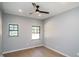 Light-filled bedroom with two windows, ceiling fan, and wood-look flooring at 1414 Whippoorwill Ln, Chapel Hill, NC 27517