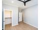 Neutral bedroom with closet and doorway, featuring clean lines, ceiling fan and wood-look floors at 1414 Whippoorwill Ln, Chapel Hill, NC 27517