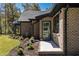 Charming brick home with a well-manicured lawn, black trim windows, and a stylish green front door at 1414 Whippoorwill Ln, Chapel Hill, NC 27517