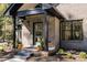 Welcoming front porch featuring a modern teal door, black pillars, and decorative plants at 1414 Whippoorwill Ln, Chapel Hill, NC 27517