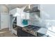 Modern kitchen with stainless steel appliances, gray backsplash, and white and gray cabinets at 1414 Whippoorwill Ln, Chapel Hill, NC 27517