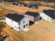 Aerial view of new homes with various siding colors and dark roofs in a community at 70 Little Creek Dr, Lillington, NC 27546