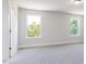 Bedroom showcasing two large windows, neutral walls and carpet, and a doorway at 70 Little Creek Dr, Lillington, NC 27546