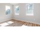 Bright bedroom with light wood floors, three large windows, and neutral walls at 70 Little Creek Dr, Lillington, NC 27546