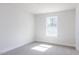 Carpeted bedroom with white walls, a window, and a door at 70 Little Creek Dr, Lillington, NC 27546