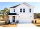New two-story home with white siding, black door, and a two-car garage at 70 Little Creek Dr, Lillington, NC 27546