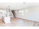 Open-concept living room featuring hardwood floors, white walls, modern lighting and staircase to the second floor at 70 Little Creek Dr, Lillington, NC 27546