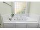 Relaxing bathroom featuring a large soaking tub, neutral paint, and ceramic tile surround at 413 Chadwick Ln, Efland, NC 27243