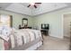 A neutral main bedroom featuring a tray ceiling, carpet flooring, and an entertainment console at 413 Chadwick Ln, Efland, NC 27243