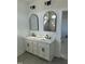 Stylish bathroom featuring double sinks, elegant black fixtures, and a framed mirror at 8536 Savage Rd, Spring Hope, NC 27882