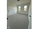 Bright bedroom with neutral carpet, white walls, and two windows providing natural light at 8536 Savage Rd, Spring Hope, NC 27882