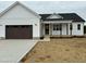 Charming new construction exterior featuring a covered porch and a two-car garage at 8536 Savage Rd, Spring Hope, NC 27882