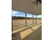 Covered back porch with wooden floors and white railings overlooks the open backyard at 8536 Savage Rd, Spring Hope, NC 27882