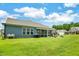 This backyard features a covered porch, patio, green lawn, and views of neighboring homes at 1401 Black Locust Ln, Fuquay Varina, NC 27526