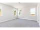 Bright bedroom featuring neutral walls, plush carpeting, and three windows offering ample natural light at 326 Little Creek Dr, Lillington, NC 27546