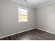 Simple bedroom with wood-look floors and a window at 501 Kendall Dr, Durham, NC 27703