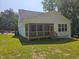 Exterior view of backyard featuring a screened-in porch and lush green lawn at 698 Magnolia Acres Ln, Fuquay Varina, NC 27526
