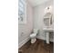 Cozy powder room featuring pedestal sink, oval mirror, and wood-look flooring at 698 Magnolia Acres Ln, Fuquay Varina, NC 27526