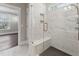 Marble shower with a shower bench, glass doors, and modern fixtures at 698 Magnolia Acres Ln, Fuquay Varina, NC 27526