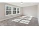 Light-filled bedroom with plush carpeting and large windows overlooking wooded property at 698 Magnolia Acres Ln, Fuquay Varina, NC 27526
