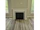 Living room fireplace with decorative mantel, marble surround, and wood-look floors at 698 Magnolia Acres Ln, Fuquay Varina, NC 27526