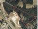 An aerial view shows land with woodlands offering privacy near highway access at 7925 S Highway 55, Willow Springs, NC 27592