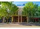 Exterior of a historic building, with symmetrical architecture framed by green trees and parked cars on the street at 10 Seawell Ave # 102, Raleigh, NC 27601