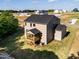 Back view of tan home with a screened in porch and large backyard in new development at 240 Fast Pitch Ln, Four Oaks, NC 27524