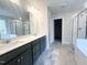 Bathroom boasts double vanity, a large mirror, enclosed shower and soaking tub at 240 Fast Pitch Ln, Four Oaks, NC 27524