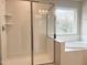 Bathroom featuring subway tile, glass shower door and a soaking tub at 240 Fast Pitch Ln, Four Oaks, NC 27524