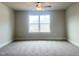 Bedroom features neutral carpeting, large window and a ceiling fan at 240 Fast Pitch Ln, Four Oaks, NC 27524