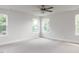 Bright bedroom with large windows offering a view of lush greenery and soft carpeting at 240 Fast Pitch Ln, Four Oaks, NC 27524
