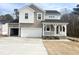 Charming two-story home with a covered porch, two-car garage, and inviting curb appeal at 240 Fast Pitch Ln, Four Oaks, NC 27524