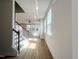 Bright foyer featuring stairs with wood and white banisters, hardwood floors, and natural light at 240 Fast Pitch Ln, Four Oaks, NC 27524