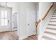 Bright foyer with hardwood floors, white walls, wood stairs, and white trim at 240 Fast Pitch Ln, Four Oaks, NC 27524