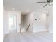Upstairs hallway featuring neutral carpet, natural lighting, and doorway with open rooms at 240 Fast Pitch Ln, Four Oaks, NC 27524