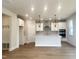Bright kitchen features a large island, modern stainless appliances and stylish pendant lighting at 240 Fast Pitch Ln, Four Oaks, NC 27524