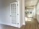 Bright living room featuring a glass paneled door, hardwood floors, and plenty of natural light at 240 Fast Pitch Ln, Four Oaks, NC 27524