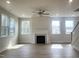 Open living room with fireplace, large windows, and wood-look flooring at 240 Fast Pitch Ln, Four Oaks, NC 27524