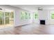 Spacious living room with wood floors, a fireplace, lots of natural light, and access to the screened porch at 240 Fast Pitch Ln, Four Oaks, NC 27524