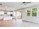 Bright living space with wood floors, a view of the kitchen, and a sliding door to the screened porch at 240 Fast Pitch Ln, Four Oaks, NC 27524