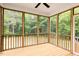 Relaxing screened-in porch with wooden floors and a view of the surrounding trees at 240 Fast Pitch Ln, Four Oaks, NC 27524