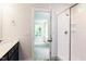 Bright bathroom featuring a glass-enclosed shower, vanity, and a connecting room with natural light at 266 Fast Pitch Ln, Four Oaks, NC 27524