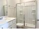 Bathroom featuring a walk-in shower with glass doors, neutral paint, and a single sink vanity at 266 Fast Pitch Ln, Four Oaks, NC 27524