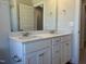 Bright bathroom featuring double vanity with white cabinets and neutral countertop at 266 Fast Pitch Ln, Four Oaks, NC 27524
