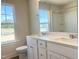 Bathroom featuring dual sinks, white cabinetry, and a large window with natural light at 266 Fast Pitch Ln, Four Oaks, NC 27524