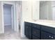 Bathroom featuring double sink vanity, gray tile, and access to closet and toilet at 266 Fast Pitch Ln, Four Oaks, NC 27524