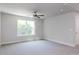 Large, carpeted bedroom with abundant natural light from a window and a ceiling fan at 266 Fast Pitch Ln, Four Oaks, NC 27524
