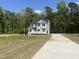 Two-story home with gray siding, an inviting front porch, a long driveway, and a spacious front yard at 266 Fast Pitch Ln, Four Oaks, NC 27524