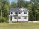 Charming two-story home with gray siding, a covered entryway, manicured landscaping, and a lush green lawn at 266 Fast Pitch Ln, Four Oaks, NC 27524